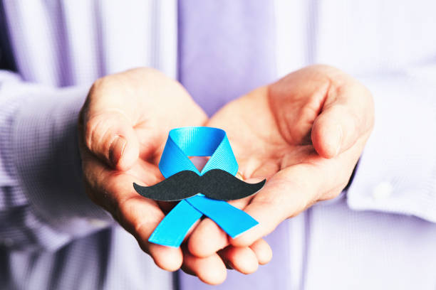 male hands holding prostate cancer awareness ribbon with mustache